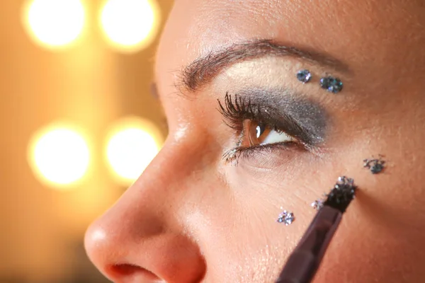 年轻漂亮的女人用刷子在眼睛上涂睫毛膏化妆品 — 图库照片