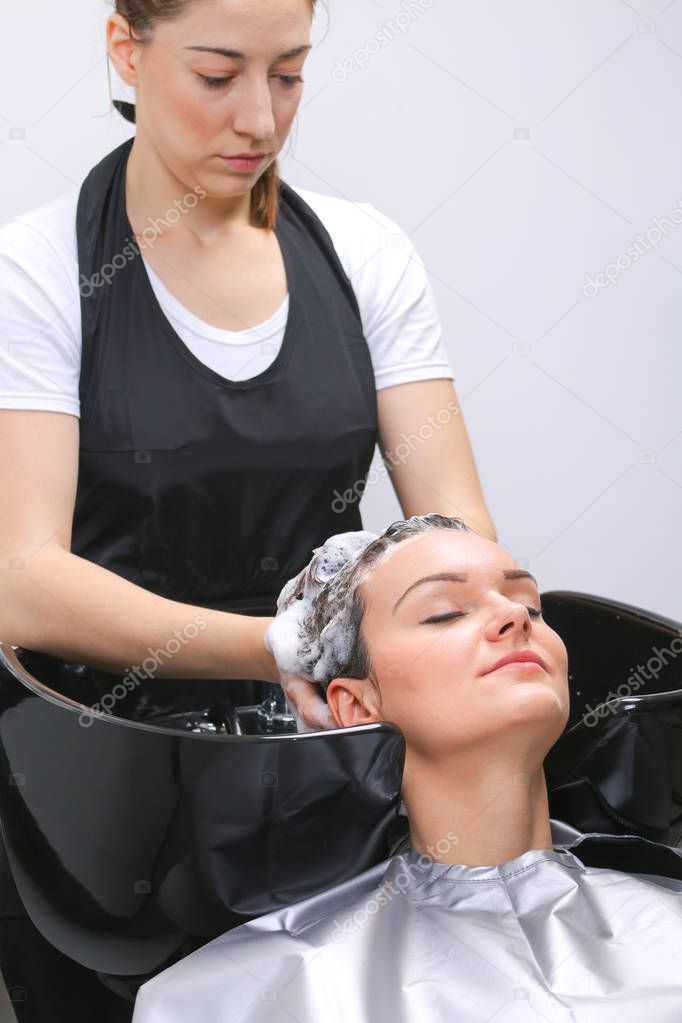 Hairdresser washing woman's hair in hairdresser salon