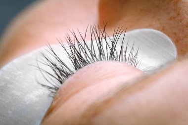 Kirpik uzatma yordamı, uzun kirpik gözle kadın