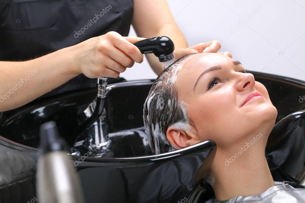 Hairdresser washing woman's hair in hairdresser salon