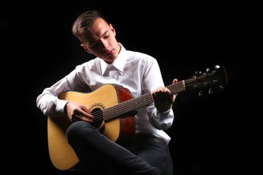 Siyah arka planda gitar çalan genç adamlar