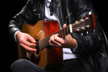 Siyah arka planda gitar çalan genç adamlar