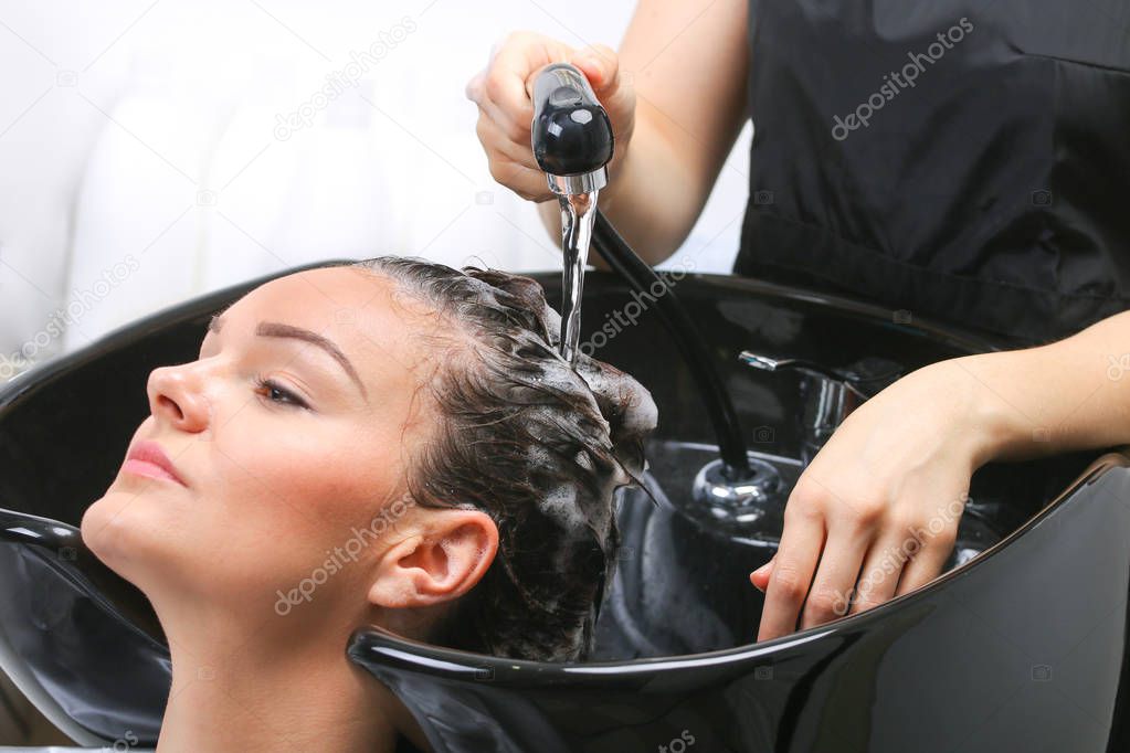 Hairdresser washing woman's hair in hairdresser salon