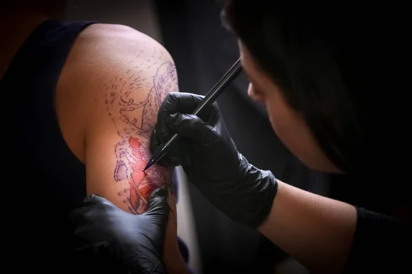Female tattoo artist making tattoo on a men`s arm — Stock Photo, Image