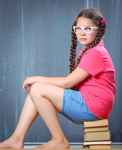 Happy school girl in front of the blackboard — Stock Photo, Image