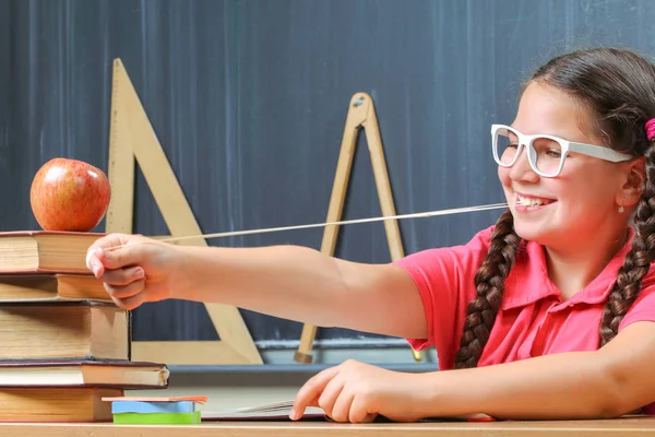 Lycklig skolflicka framför svarta tavlan — Stockfoto