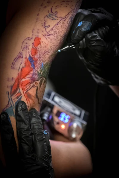 Kobiece tatuażysta co tatuaż na ramieniu dla mężczyzn — Zdjęcie stockowe