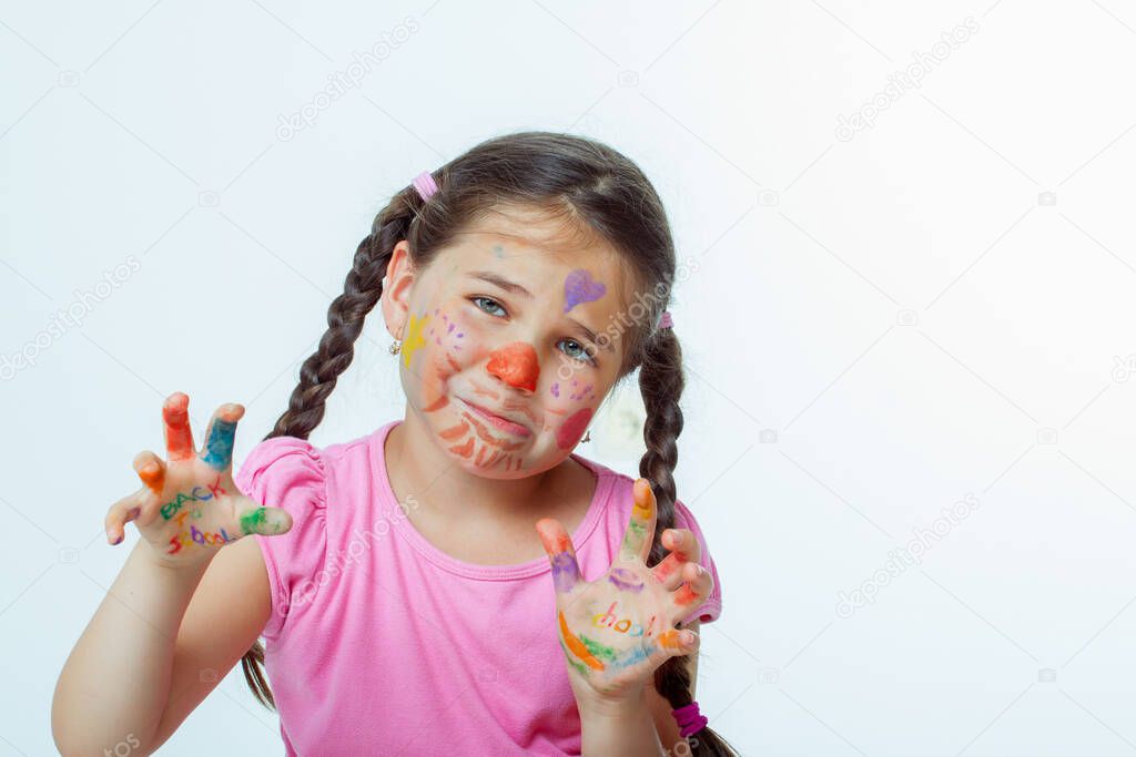 Beautiful little girl with her hands full of paint
