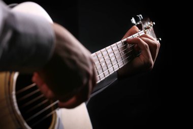 Siyah arka planda gitar çalan genç adamlar