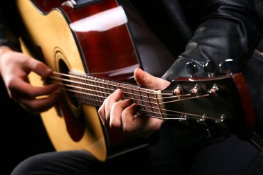 Siyah arka planda gitar çalan genç adamlar