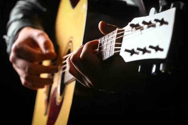 Siyah arka planda gitar çalan genç adamlar