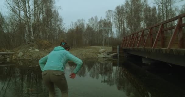 Mujer toca suavemente la superficie del agua en el río bosque o lago — Vídeo de stock