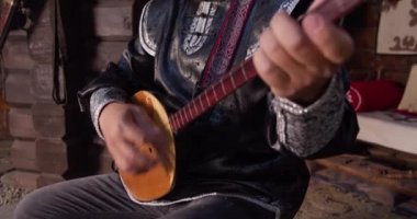 Tırabzanlar açık, eller yakın. Asyalı genç ve çekici şarkıcı boğazından şarkı söylüyor.