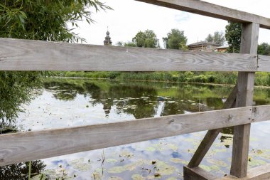 Durgun suyu ve ahşap köprüsü olan gölet