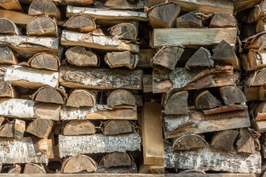 Odunlukta yakacak odun, kış için hazır. Yakacak odun yığını. Yakacak odun arka planı. Dışarıda düzgünce istiflenmiş, kuru odun yığını..