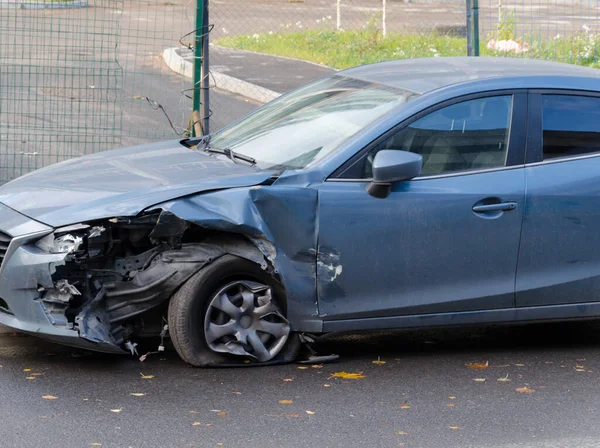 an old blue car after an accident with a broken wing and left door. auto accident rusty old car. broken glass at the car