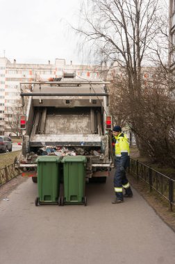 St. Petersburg, Rusya - 03.10.20: bir belediye atık geri dönüşüm fabrikasında çalışan bir işçi çöp kutularını yüklemeye hazırlıyor.