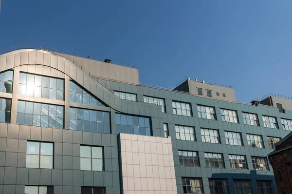 Panoramik pencereli modern bir ofis binasının ön cephesi..