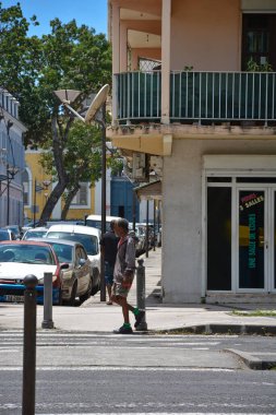 Point-a-Pitre, Guadeloupe - 17 Eylül 2018: Kirli elbiseli, gri saçlı, kazaklı, şortlu, spor ayakkabılı evsiz adam