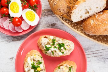 Uskumru veya ton balığı Yapıştır, yumurta, domates, turp ve taze huysuz baget hasır sepet içinde rulo