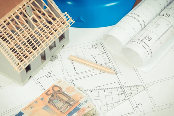 Currencies euro, electrical diagrams, accessories for use in engineer jobs and small toy house under construction, concept of building home cost