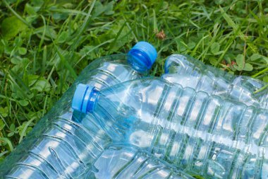 Plastik şişe maden suyu park, çevre koruma kavramı ve çevre çöp çimenlerin üzerinde