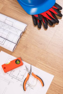 Şema veya elektrik inşaat çizimleri, eldiven ve turuncu iş araçları, koruyucu mavi kask için mühendis işlerde aksesuar