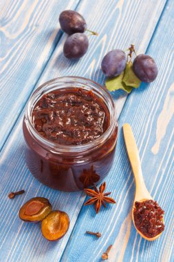 Taze erik reçel veya marmelat cam kavanoz, olgunlaşmış meyve ve baharat panoları, sağlıklı tatlı tatlı kavramı