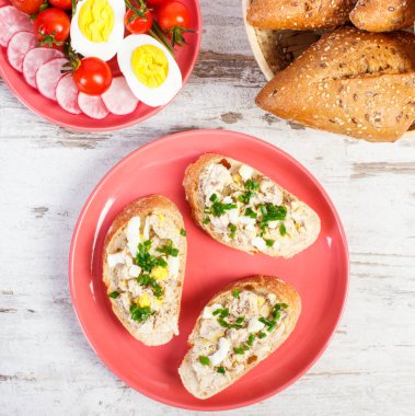 Ev yapımı hamur uskumru veya ton balığı, yumurta, domates, turp ve taze huysuz baget hasır sepet içinde rulo