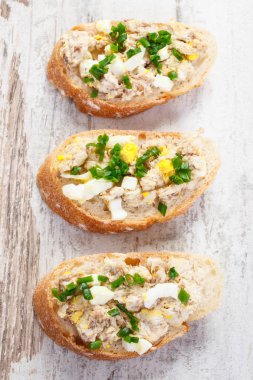 Taze ev yapımı hamur uskumru veya ton balığı, yumurta ve eski rustik gemide chives ile sandviç