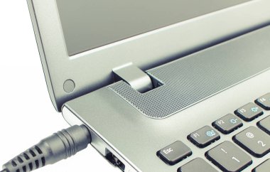 Beyaz arka plan üstünde laptop şarj cihazı tak bağlı