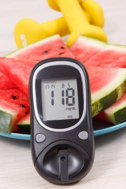 Karpuz, fitness, sağlıklı yaşam, beslenme ve zayıflama kavramı için şeker seviyesi ve dumbell ile şekeri ölçüm cihazı