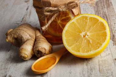 Cam, tahta kaşık ve zencefil, sağlıklı gıda, beslenme ve bağışıklık güçlendirme kavramı üzerinde bal bal limon