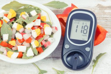 Şeker seviyesini ölçmek için glikoz ölçer ve sebze ve yumurtalı taze bezelye salatası, diyabet ve sağlıklı yaşam tarzları ve beslenme kavramı