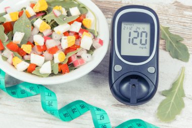 Şeker seviyesini kontrol etmek için glikoz ölçer, mezura ve sebze ve yumurtalı taze salata, diyabet, zayıflama ve sağlıklı yaşam tarzları ve beslenme kavramı