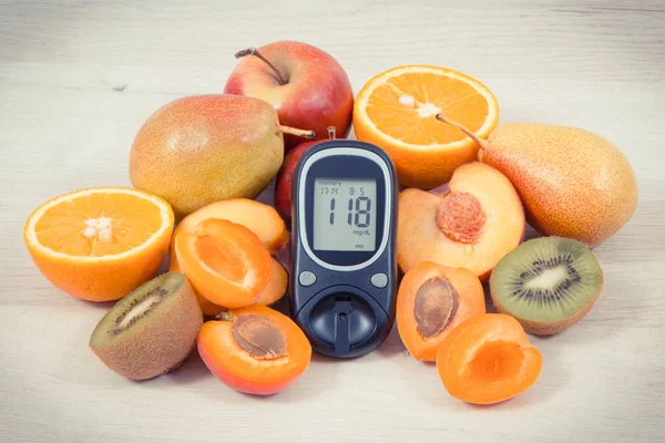 Glucose meter with result of measurement sugar level and fresh nutritious fruits as healthy dessert for diabetics