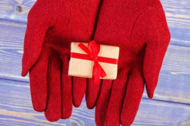 Eller kadının kırmızı yün eldiven ve yılbaşı, Sevgililer günü, doğum günü veya diğer kutlama için sarılmış hediye
