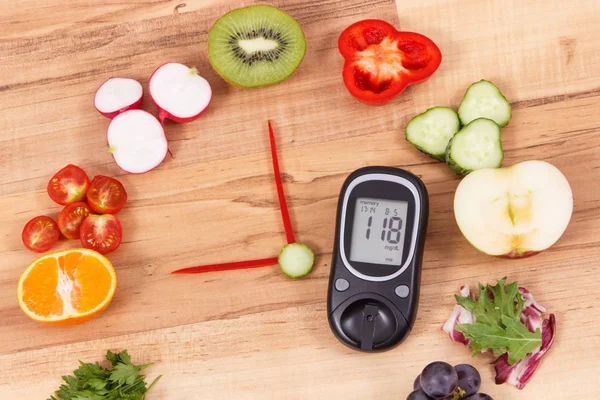 Glucose meter for checking sugar level and fresh ripe fruits with vegetables in shape of clock, concept of healthy food for diabetics