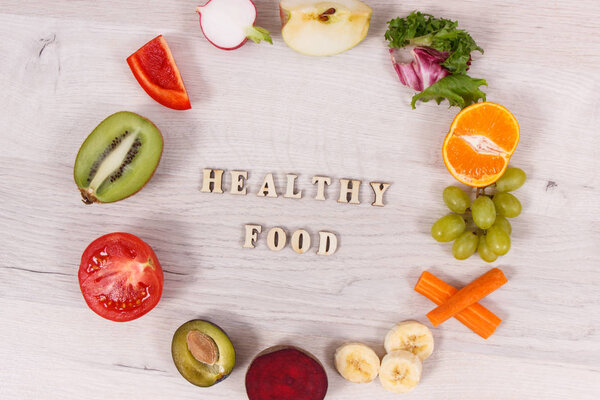 Inscription healthy food with fresh ripe fruits and vegetables containing natural vitamins
