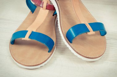 Beyaz tahta, tatilde kullanmak için ayakkabı kavramı üzerinde kadınca deri sandalet çifti