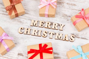 Noel için renkli kurdelelerle paketlenmiş hediyeler eski köy tahtasında yatıyor.