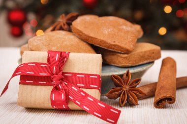 Xmas, plaka ve Baharatlar, gingerbreads sarılmış hediye şeritler ışıklar arka planda ile Noel ağacı