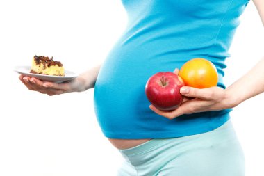Kadın hamile tutarak taze portakal ve elma ve parçası cheesecake, hamilelik döneminde sağlıklı beslenme kavramı