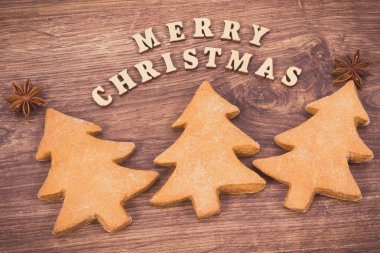 Taze pişmiş ev yapımı zencefilli ekmek ya da Noel ağacı şeklinde neşeli kurabiyeler ve yazıtlar Mutlu Noeller.