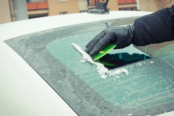 拿着手套拿着绿色刮刀 从车窗上除冰或雪 运输中冬季问题的概念 — 图库照片