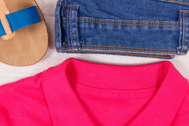 Kadınlar için şık ve rahat deri sandaletler, mavi kot pantolon ve kırmızı pamuklu gömlek veya kazak