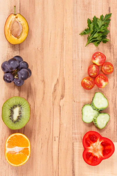 Frame of fresh fruits and vegetables as healthy and nutritious eating, place for text or inscription on rustic plank