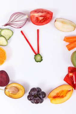 Saat şeklinde sebzeli taze meyveler. Yeni yıl çözümleri ve sağlıklı beslenme zamanı
