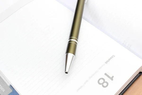 オーガナイザーを開くまたはカレンダーのオフィスでの机の上に横たわっているペンのクローズ アップ — ストック写真