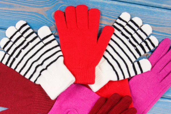 Red, pink and striped womanly gloves for autumn or winter, warm clothing concept